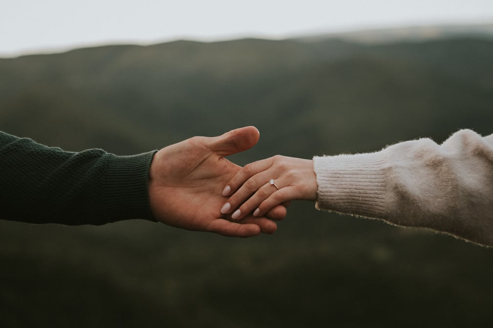 Female Hand with Engagement Ring Holding Male Hand